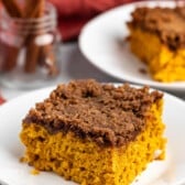 square slice of pumpkin coffee cake on a white plate.