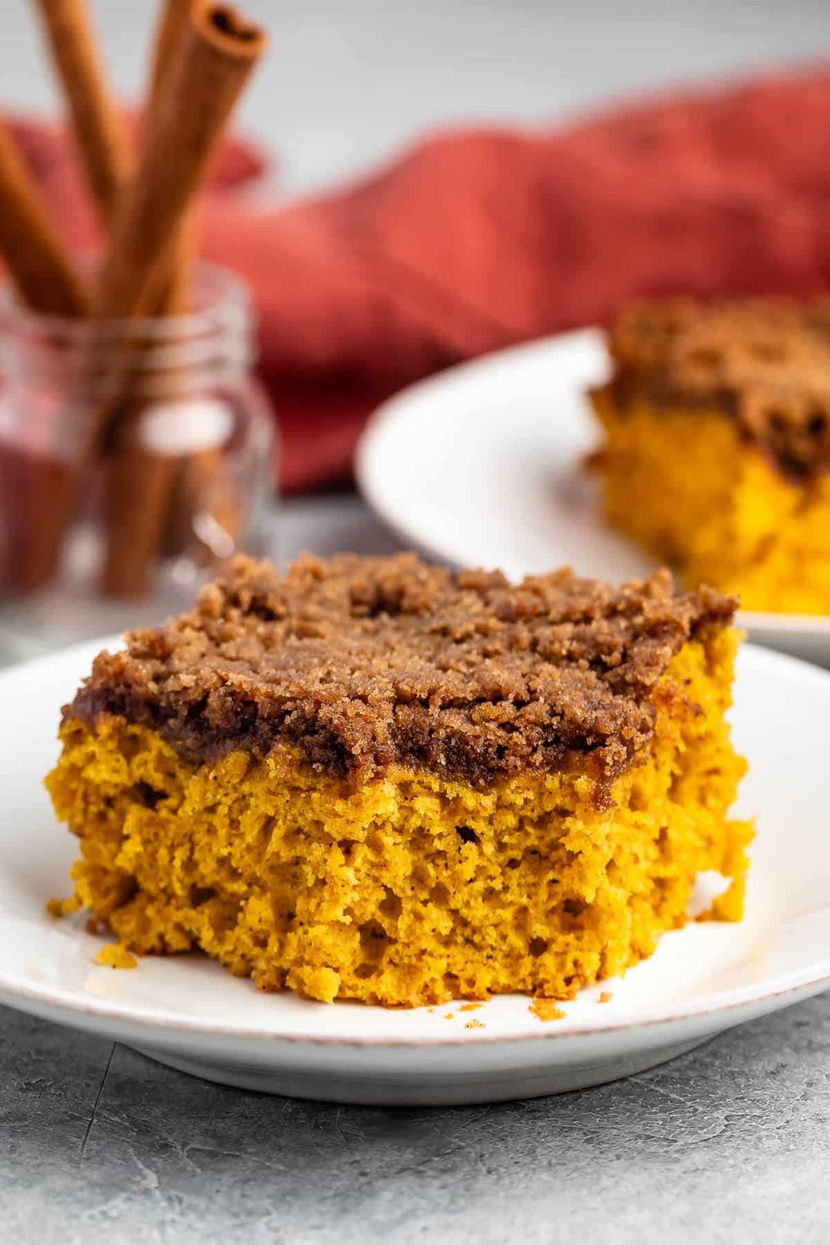square slice of pumpkin coffee cake on a white plate.