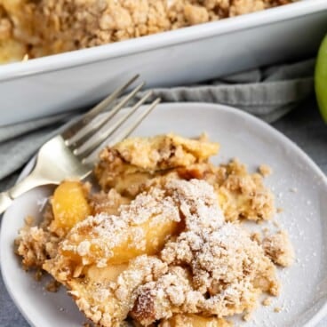 apple pie casserole on a grey plate with a crumble in top.