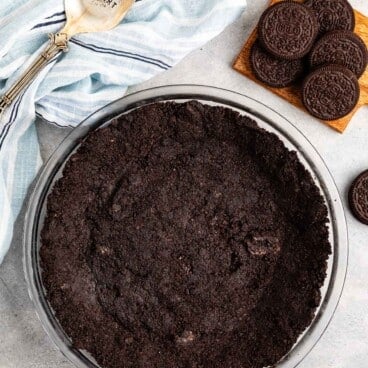 Oreo cookies pressed into a clear pan making an Oreo crust.
