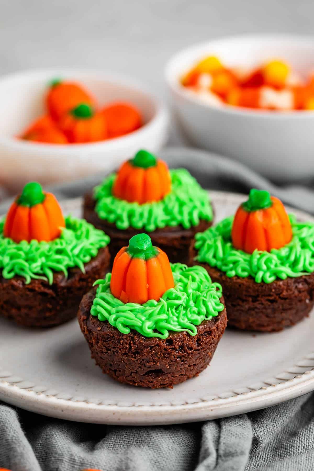 brownie bites topped with green frosting and a pumpkin candy corn.
