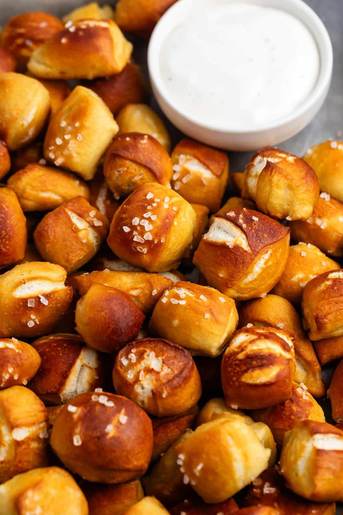soft pretzel bites piled on top of each other with thick salt on top.