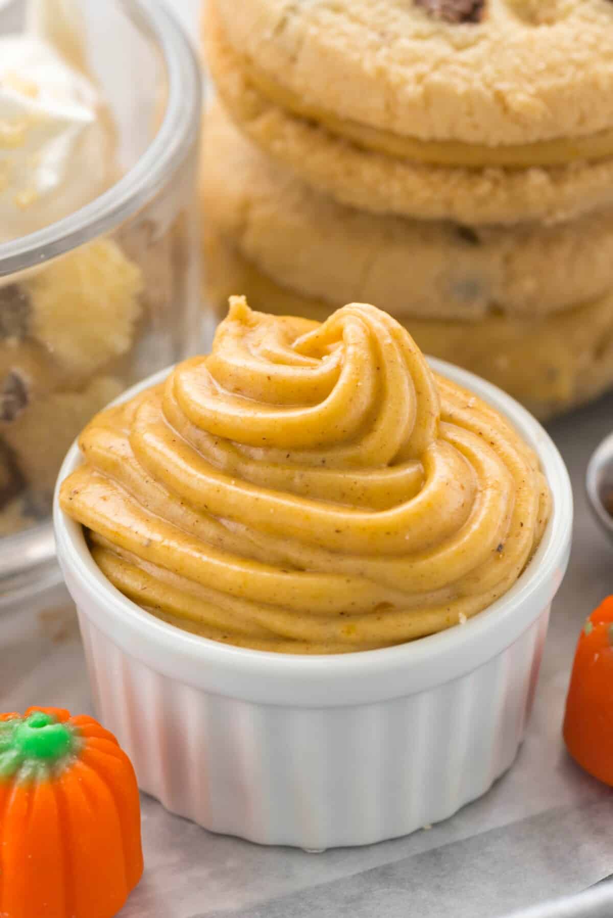 pumpkin frosting piped into a white ceramic dish.