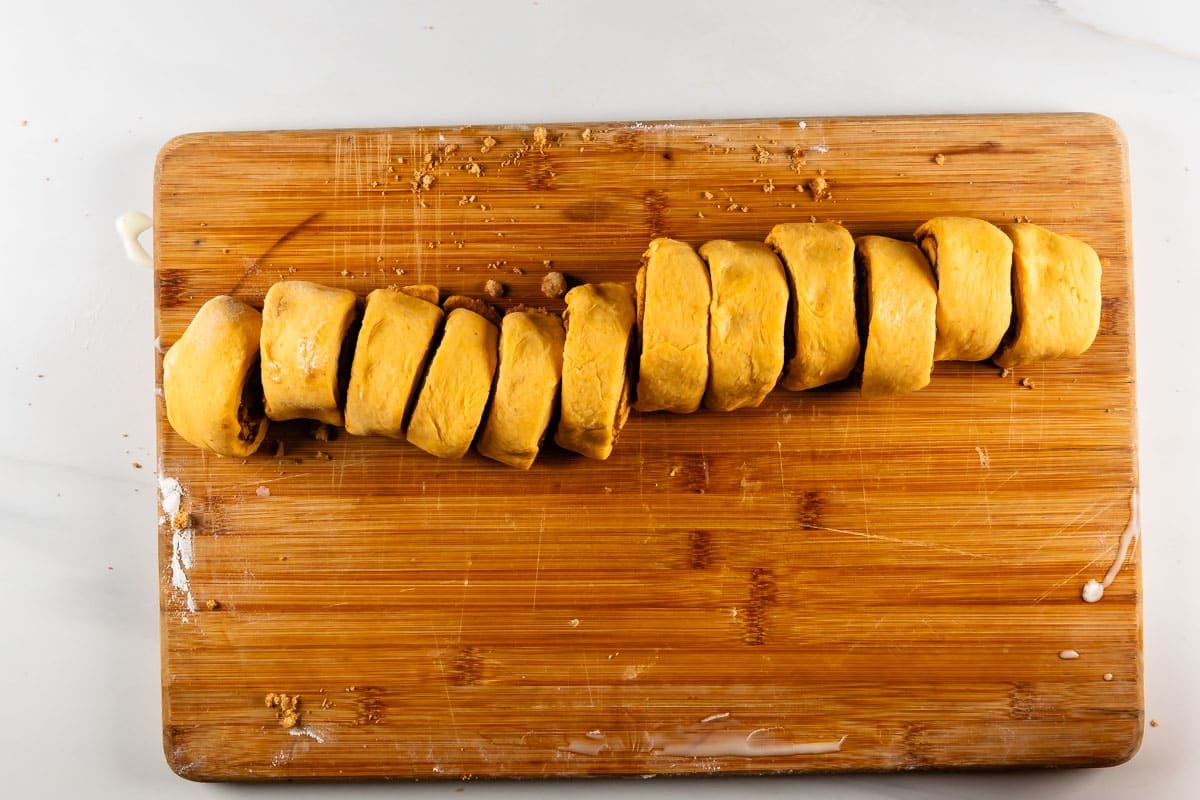 process shot of pumpkin cinnamon rolls being made.