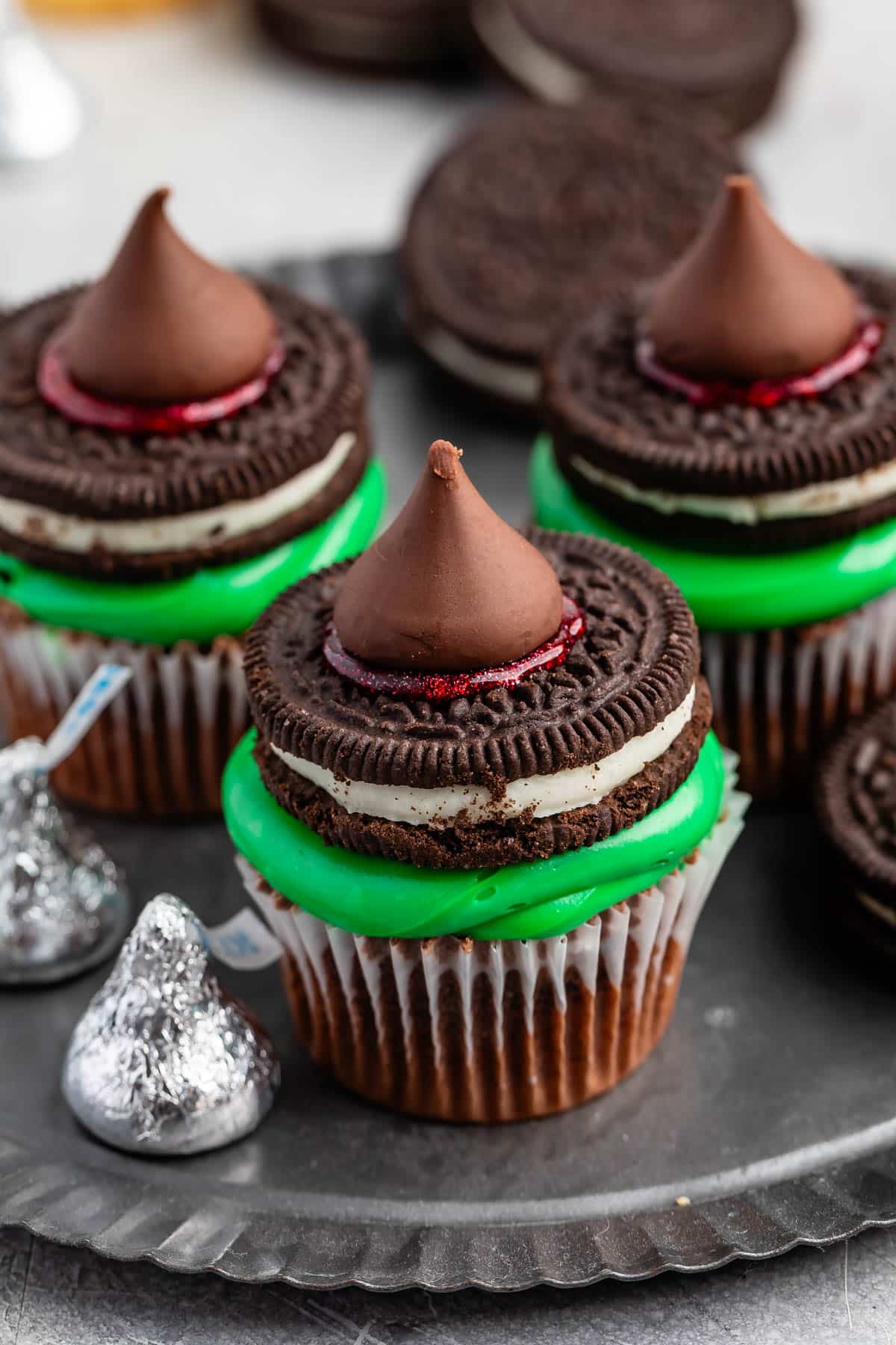 cupcakes with green frosting and a Oreo and kiss on top.