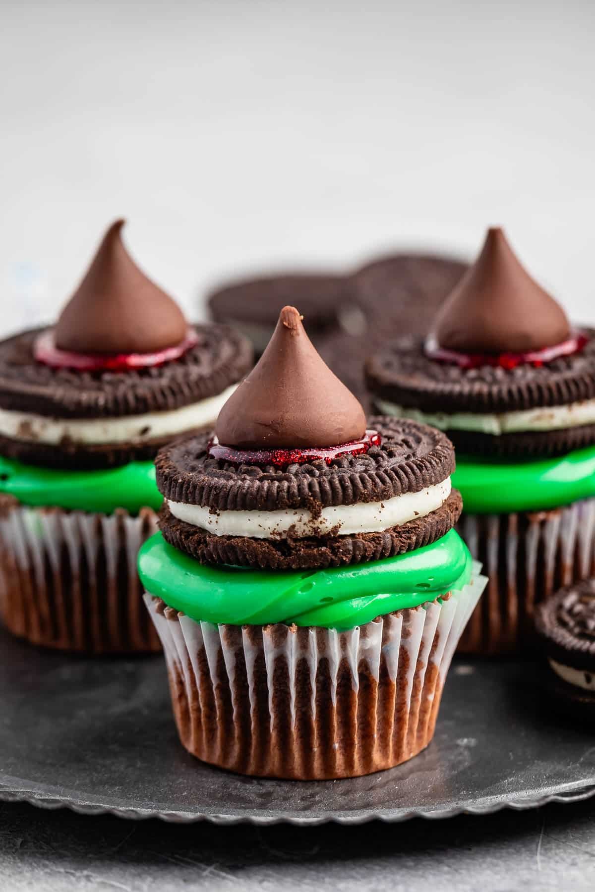 cupcakes with green frosting and a Oreo and kiss on top.