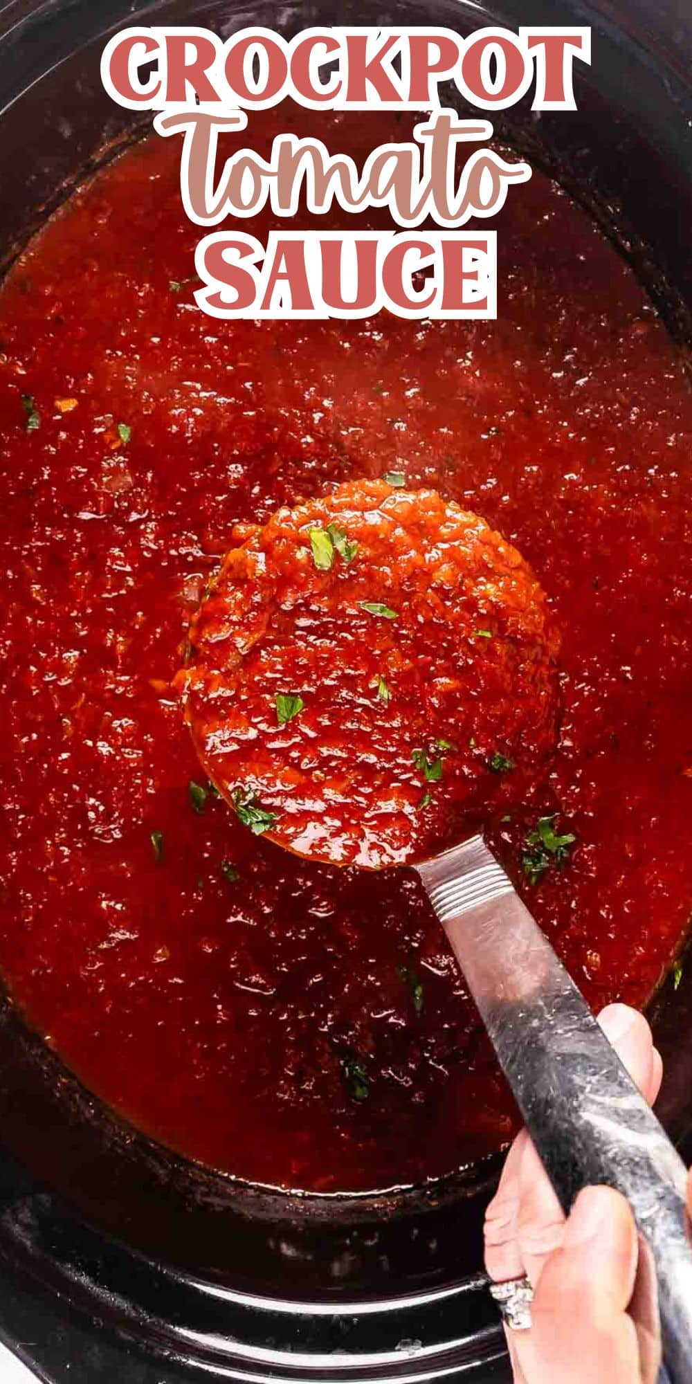 A close-up of a crockpot filled with tomato sauce. A hand holds a ladle, scooping some of the sauce, which is garnished with chopped herbs. At the top, text reads Crockpot Tomato Sauce.