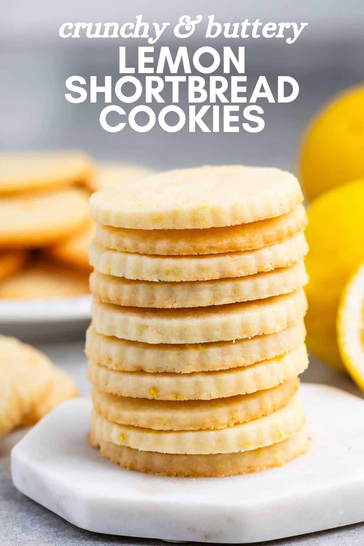 A stack of round lemon shortbread cookies sits on a marble board, their golden edges perfectly textured. Sliced lemon peeks from the background, enhancing the images citrus allure. The text proudly declares: Crunchy & buttery lemon shortbread cookies.