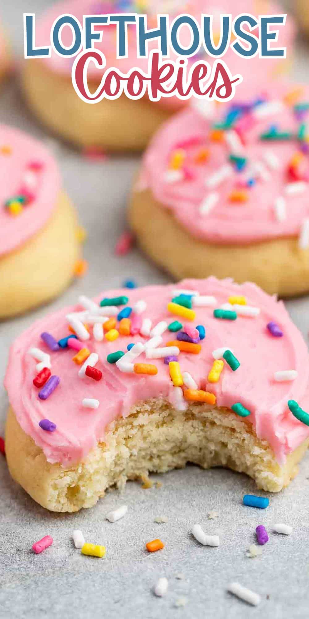 A Lofthouse cookie with pink frosting and colorful sprinkles, featuring a bite taken out of it. Other similar cookies are blurred in the background. The text Lofthouse Cookies is displayed at the top.