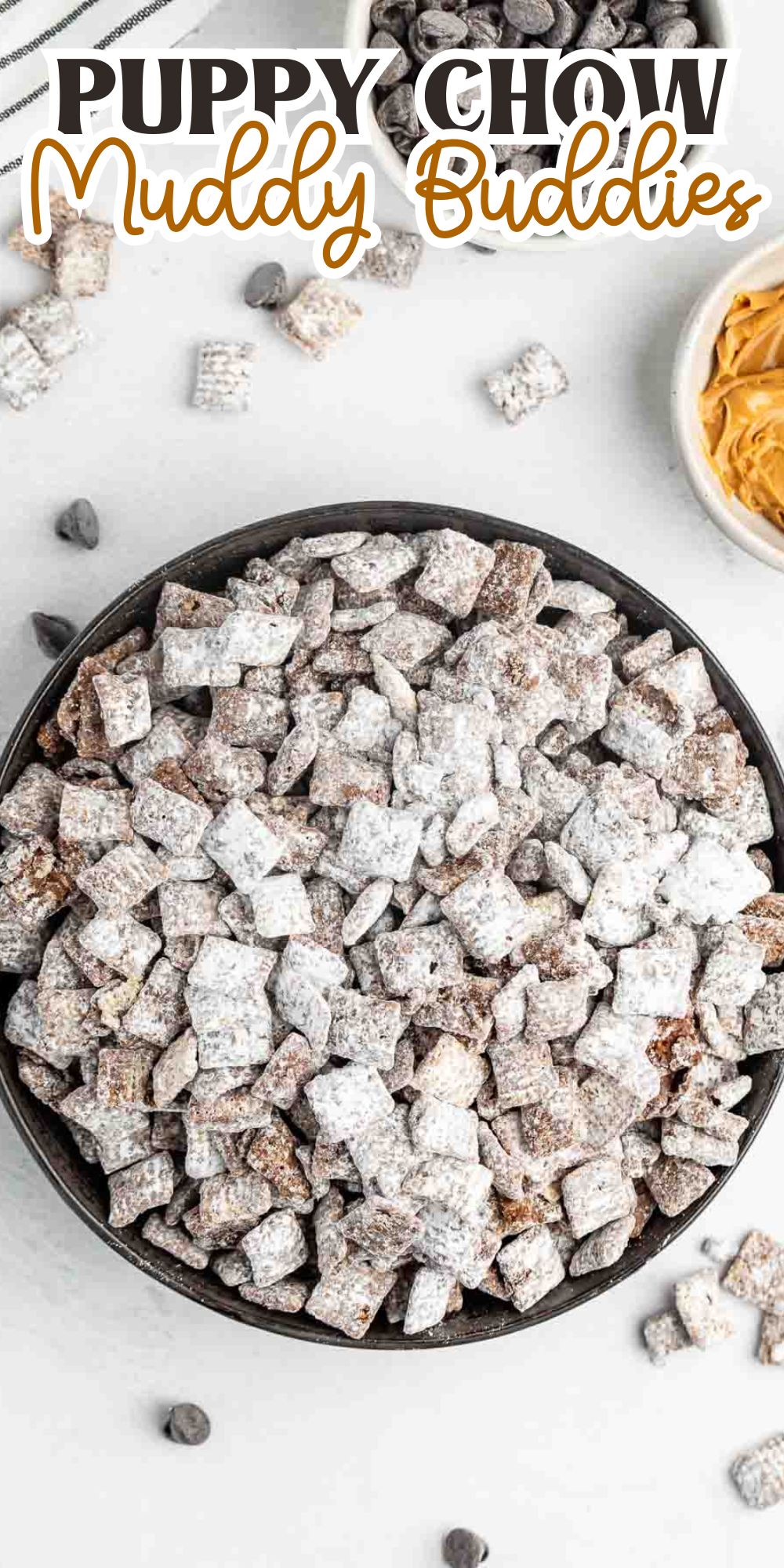 A bowl of Puppy Chow Muddy Buddies, coated in powdered sugar, is placed on a white surface. Nearby are ingredients like chocolate chips and a bowl of peanut butter. Text above reads Puppy Chow Muddy Buddies.