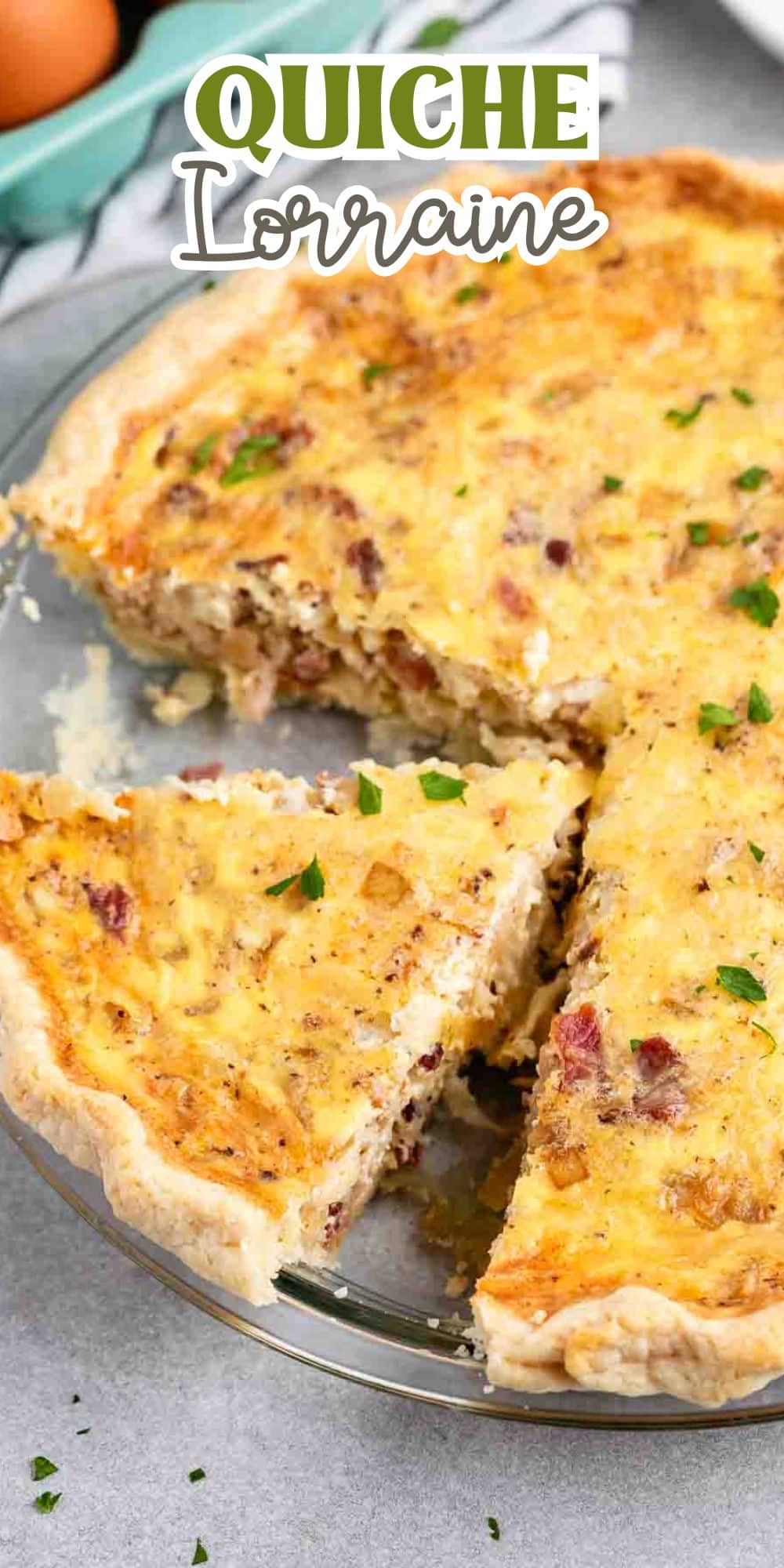 A quiche Lorraine with a slice taken out, revealing its creamy interior with visible bacon pieces and sprinkles of herbs on top. The words Quiche Lorraine are written above.