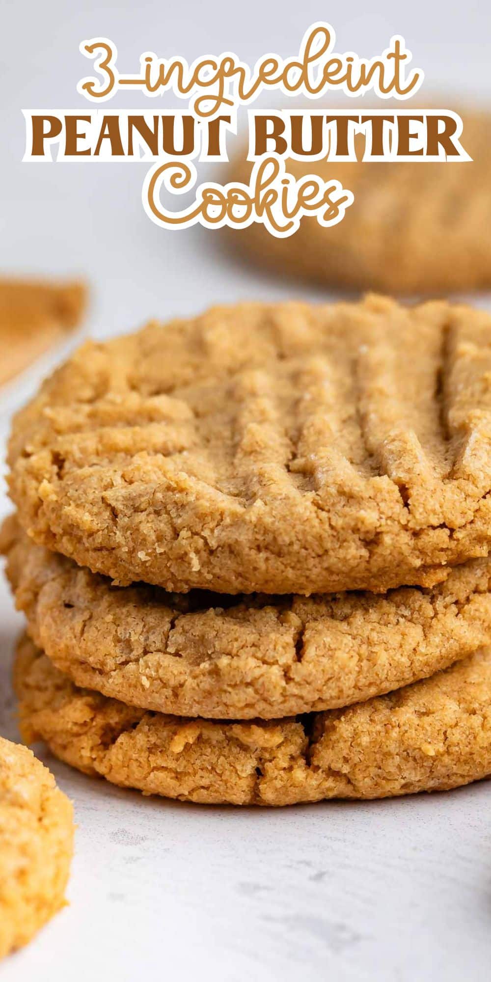 Stack of three golden, crisscross-topped peanut butter cookies on a light surface with text above reading 3-ingredient peanut butter cookies.