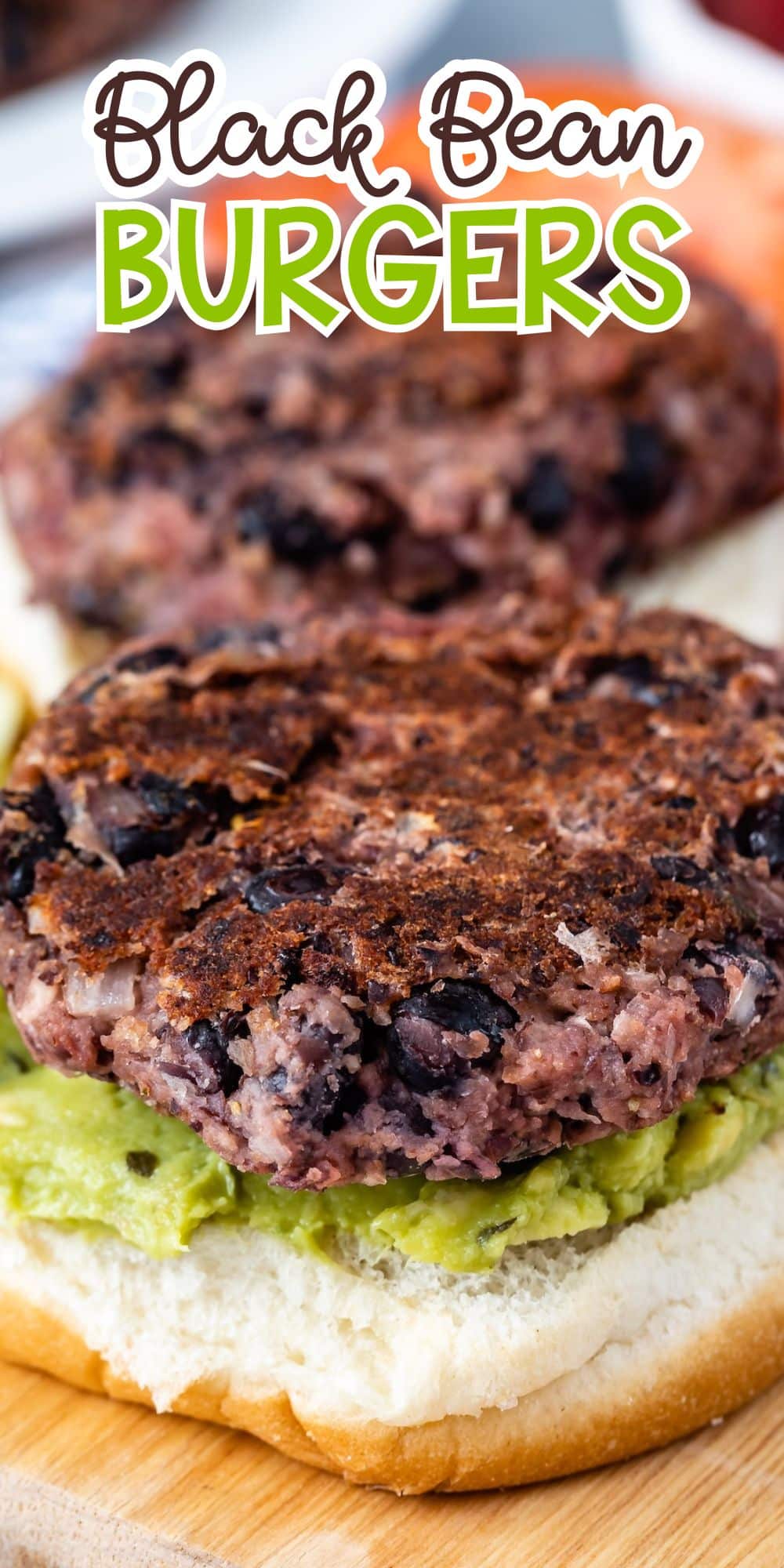 A close-up of a black bean burger patty on an open bun, layered on top of mashed avocado. The text Black Bean Burgers is overlaid at the top of the image.