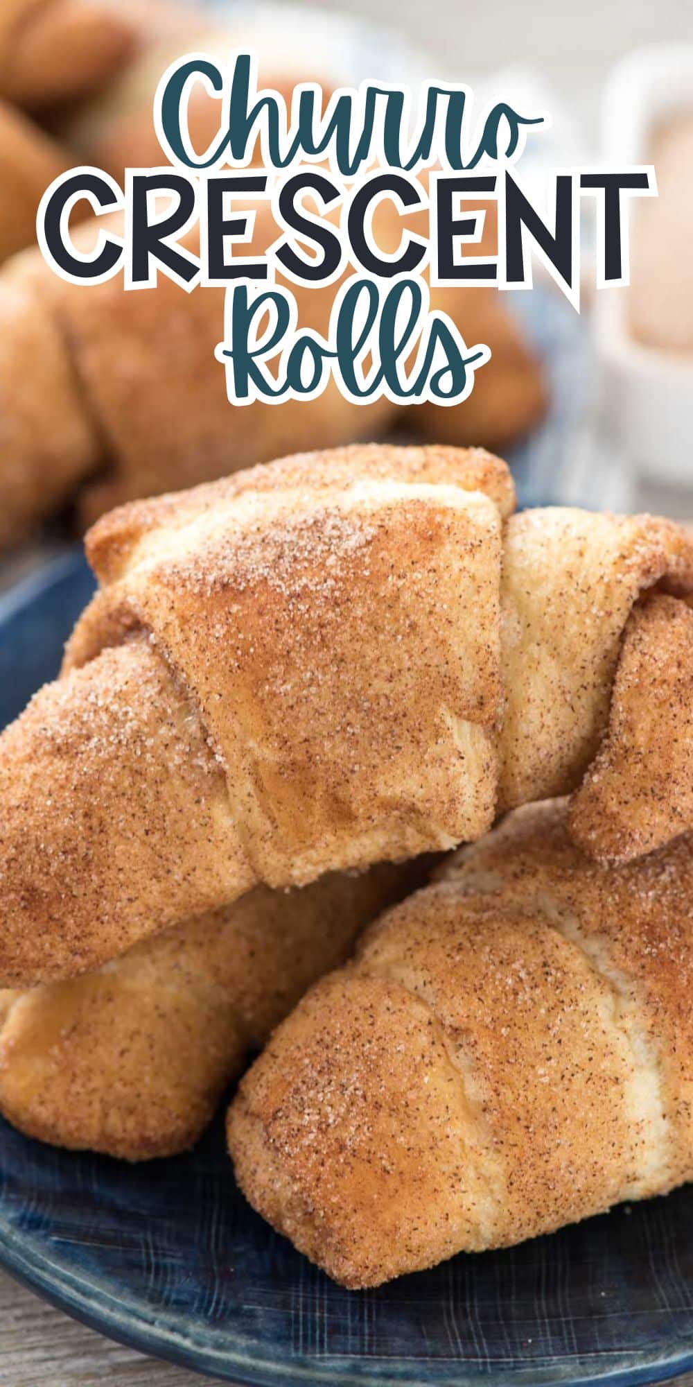 Close-up of freshly baked churro crescent rolls on a blue plate, sprinkled with cinnamon sugar. Text above reads Churro Crescent Rolls.