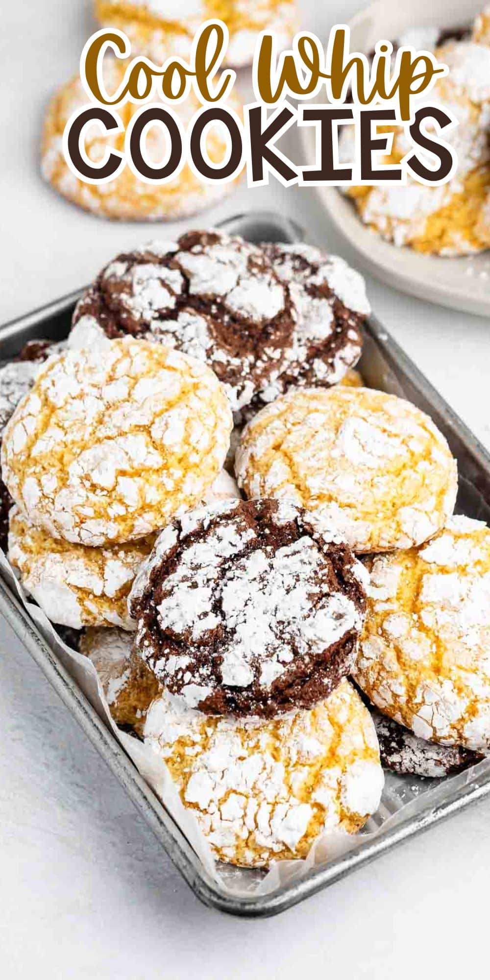 A tray filled with yellow and chocolate crinkle cookies dusted with powdered sugar, with the text Cool Whip Cookies displayed above the cookies.