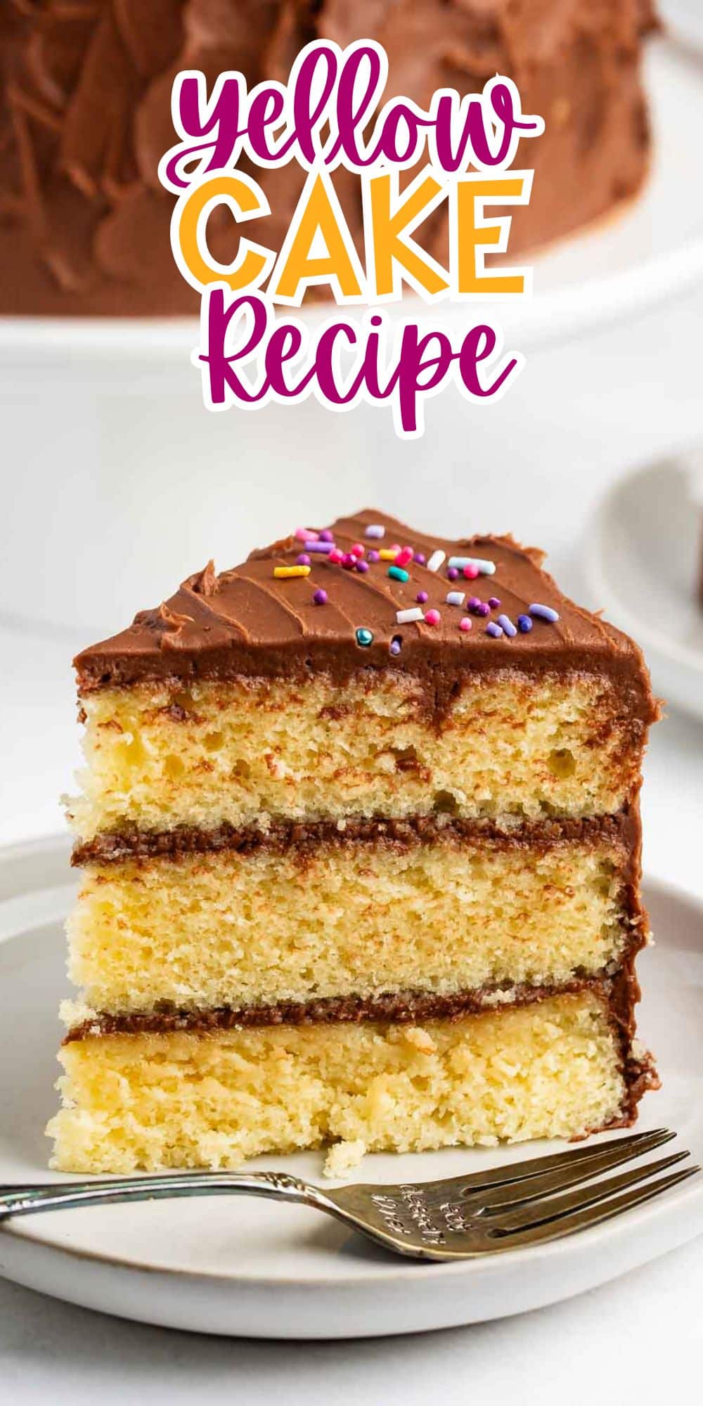 A slice of yellow cake with chocolate frosting and colorful sprinkles on a white plate. A fork is placed in front. The text above reads Yellow Cake Recipe. Another part of the cake is visible in the background.