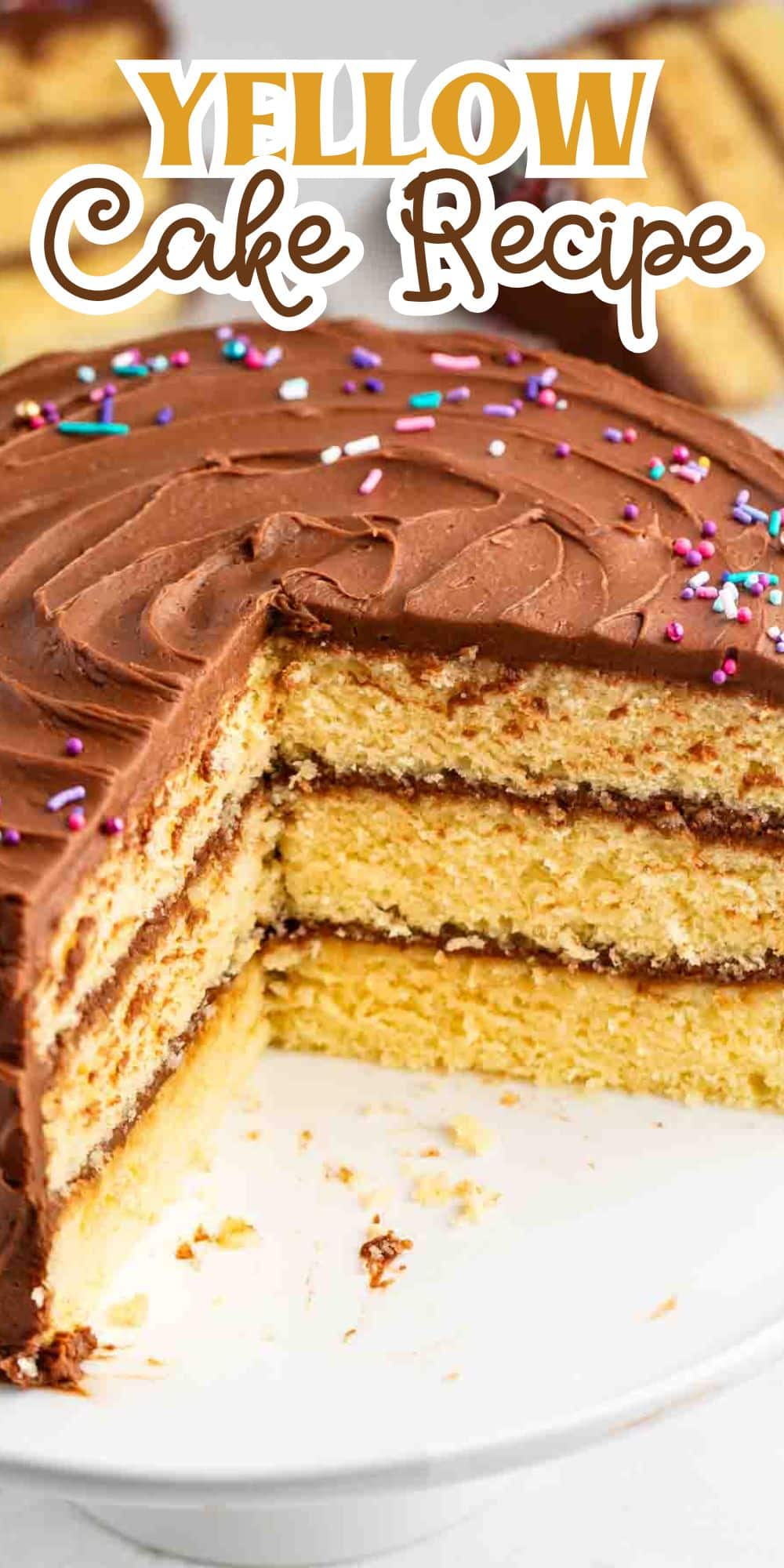 A three-layer yellow cake with chocolate frosting and colorful sprinkles sits on a white plate. A slice is missing, revealing the cakes interior. The top of the image has text: Yellow Cake Recipe.
