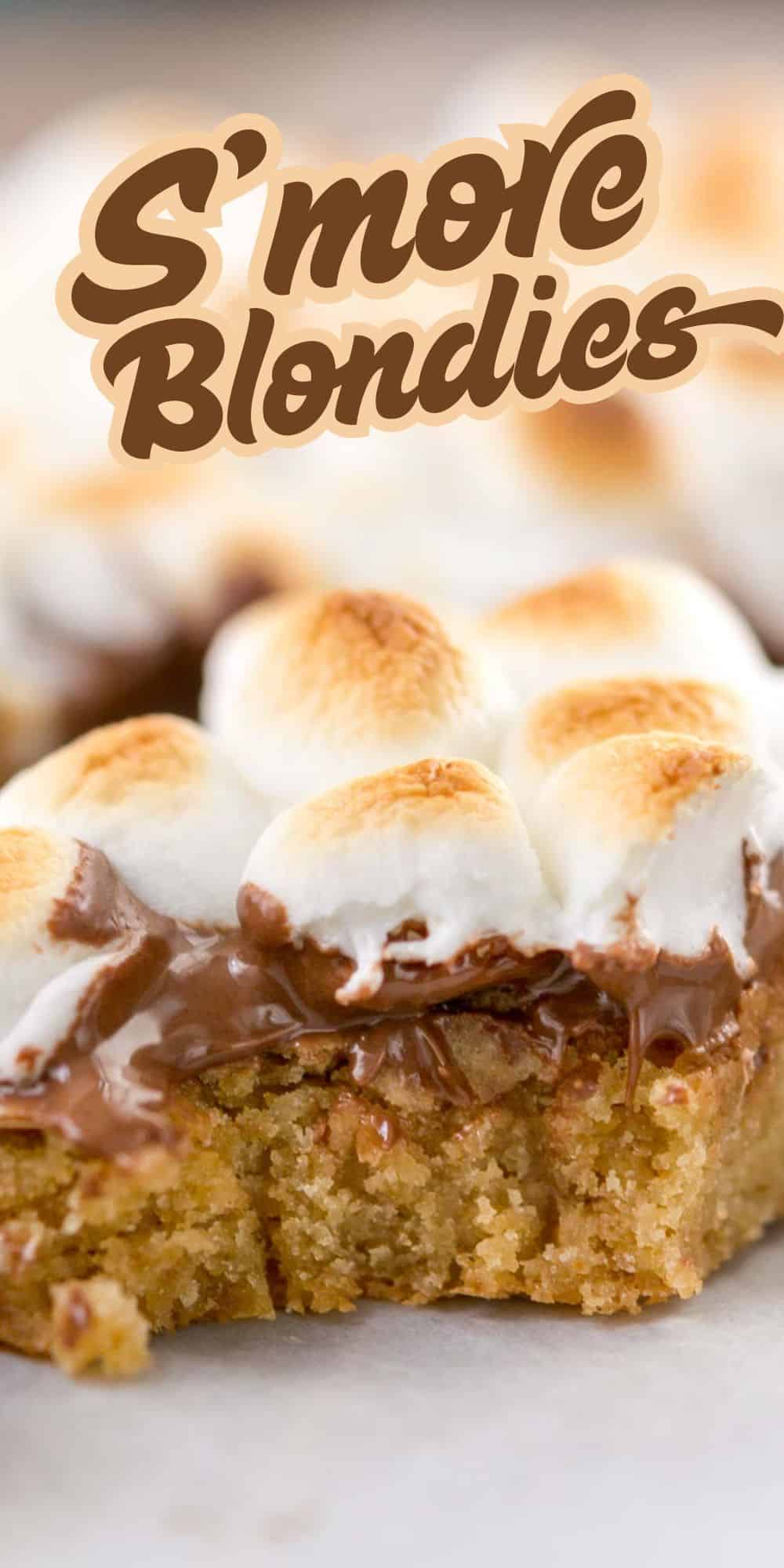 A close-up of a s’more blondie bar topped with toasted marshmallows and melted chocolate, with the text “S’more Blondies” above it. The dessert looks gooey and freshly baked.