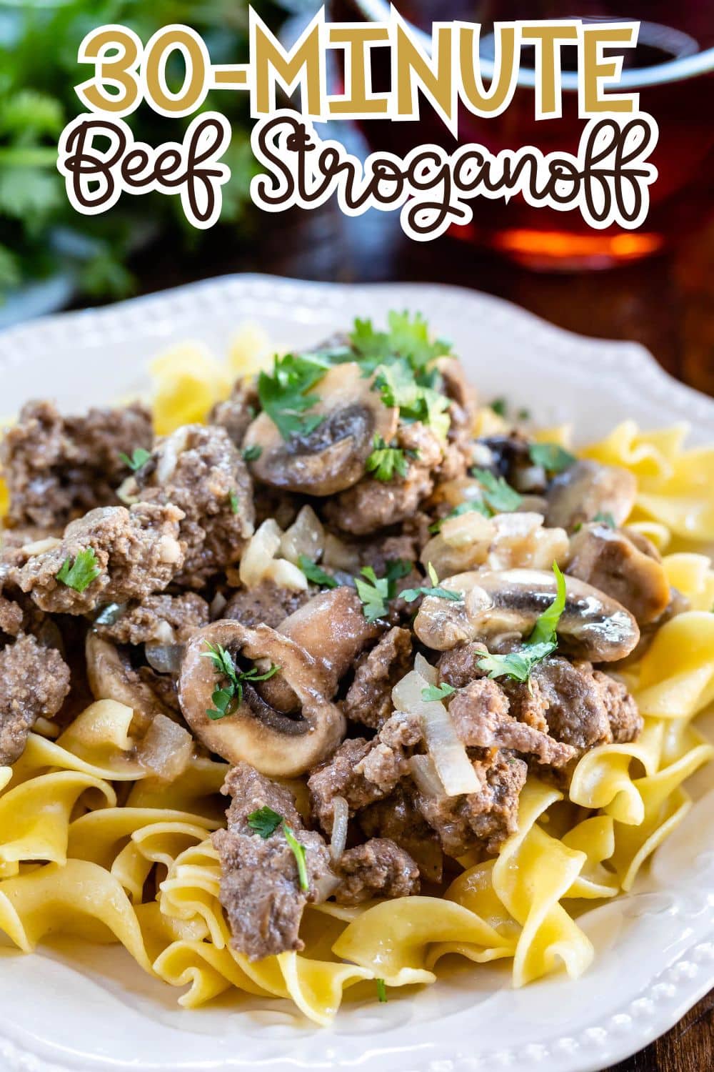 A plate of beef stroganoff with ground beef, mushrooms, onions, and parsley served over egg noodles. The text 30-Minute Beef Stroganoff appears at the top of the image.