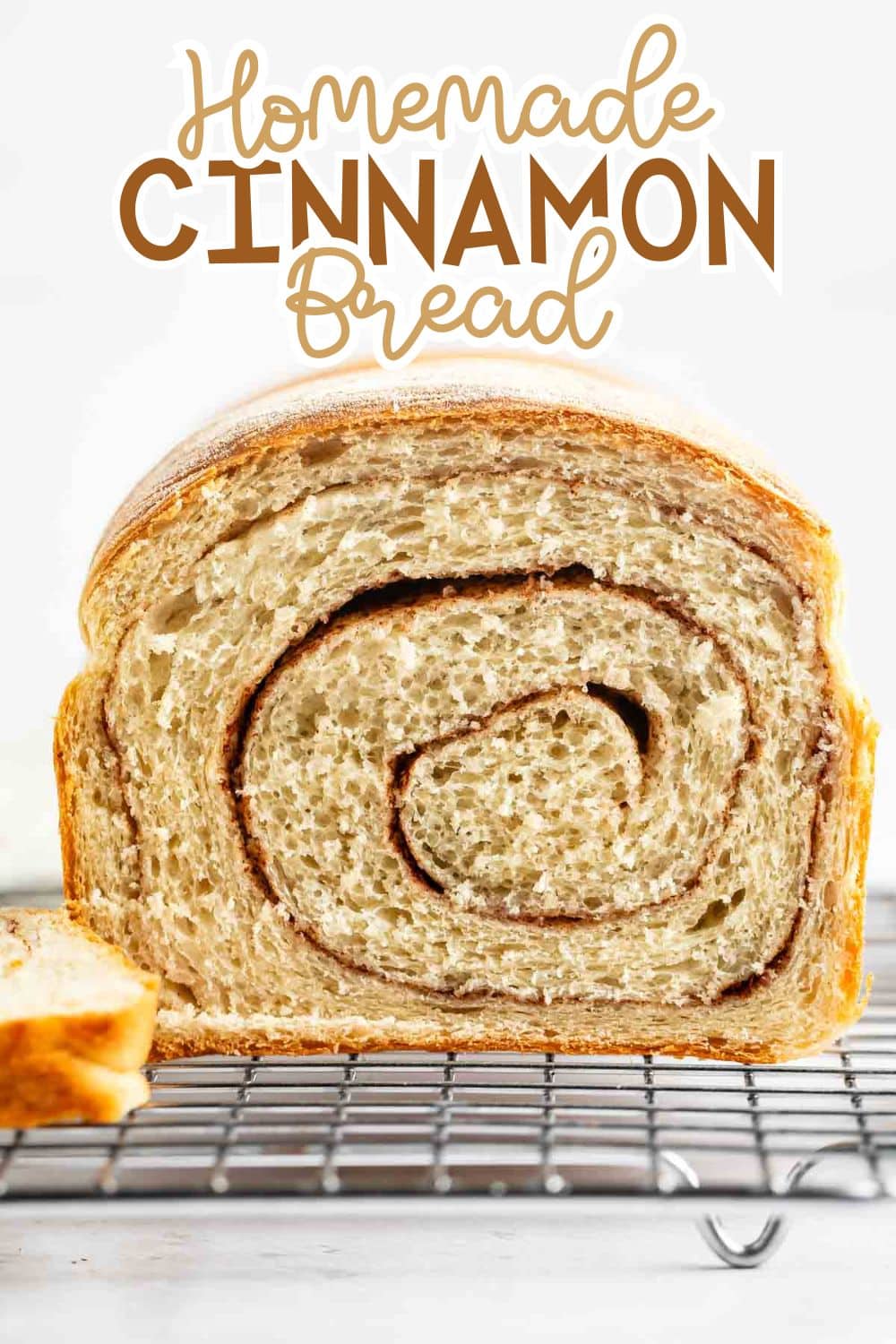 A close-up of a thick slice of homemade cinnamon bread with a visible cinnamon swirl, resting on a cooling rack. The words Homemade Cinnamon Bread are written at the top of the image in decorative fonts.