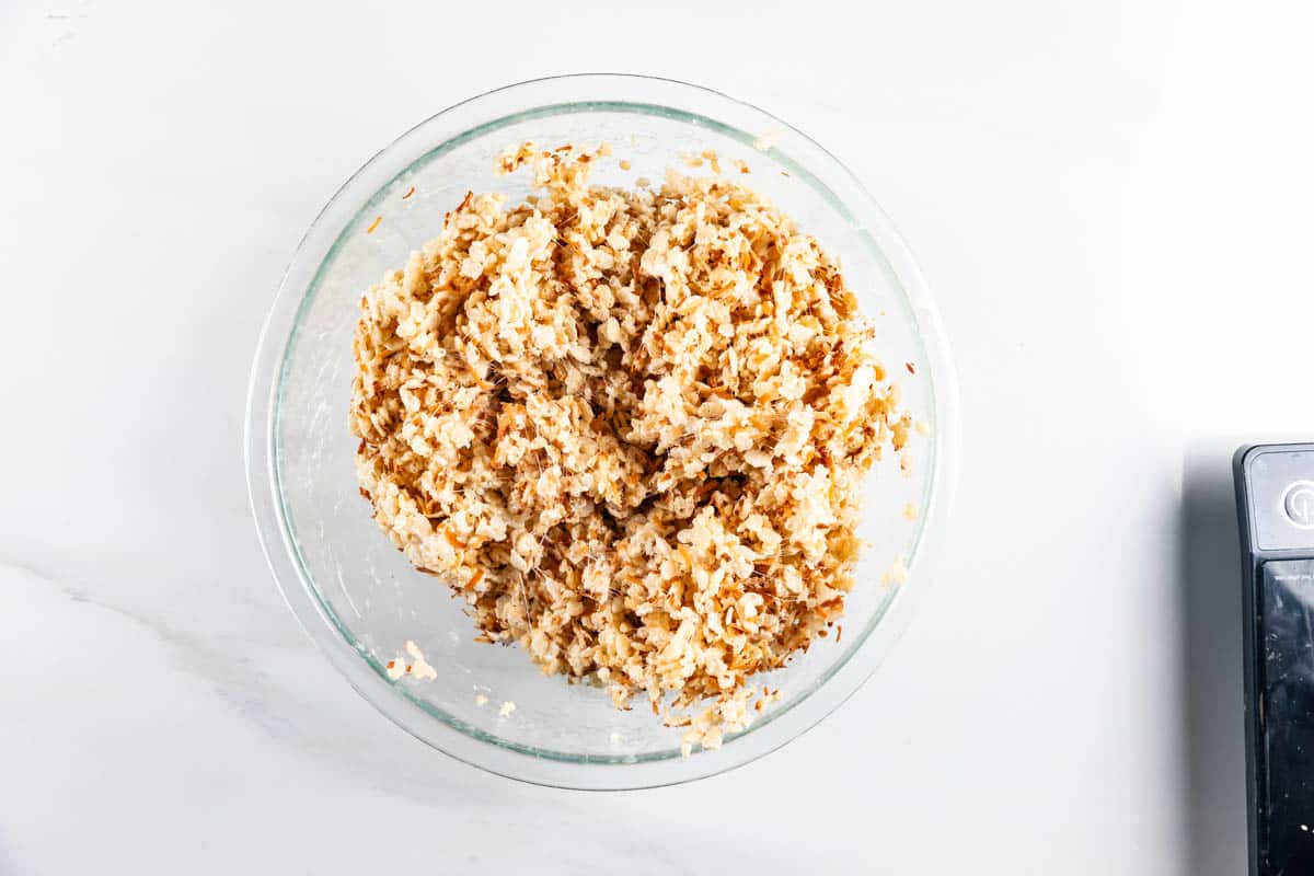 A glass bowl filled with a mixture of cooked brown and white rice sits on a white countertop.