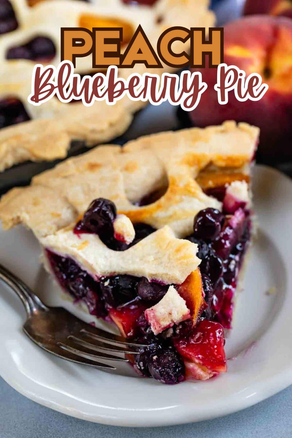 A slice of peach blueberry pie with a golden lattice crust sits on a white plate with a fork. Fresh blueberries and peach pieces are visible in the filling. Text reads Peach Blueberry Pie.