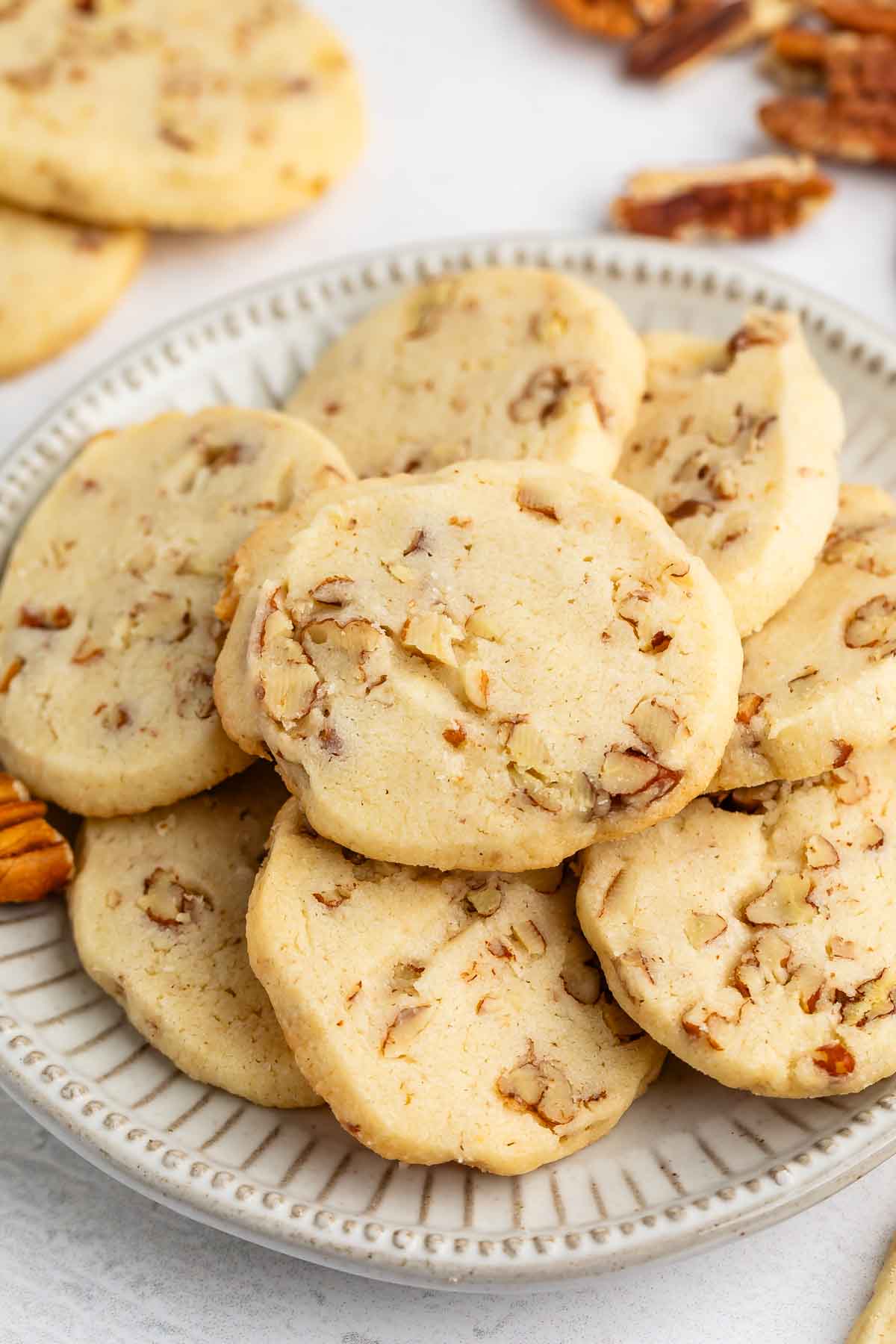 sliced cookies with pecans baked in and laid out on a grey plate.