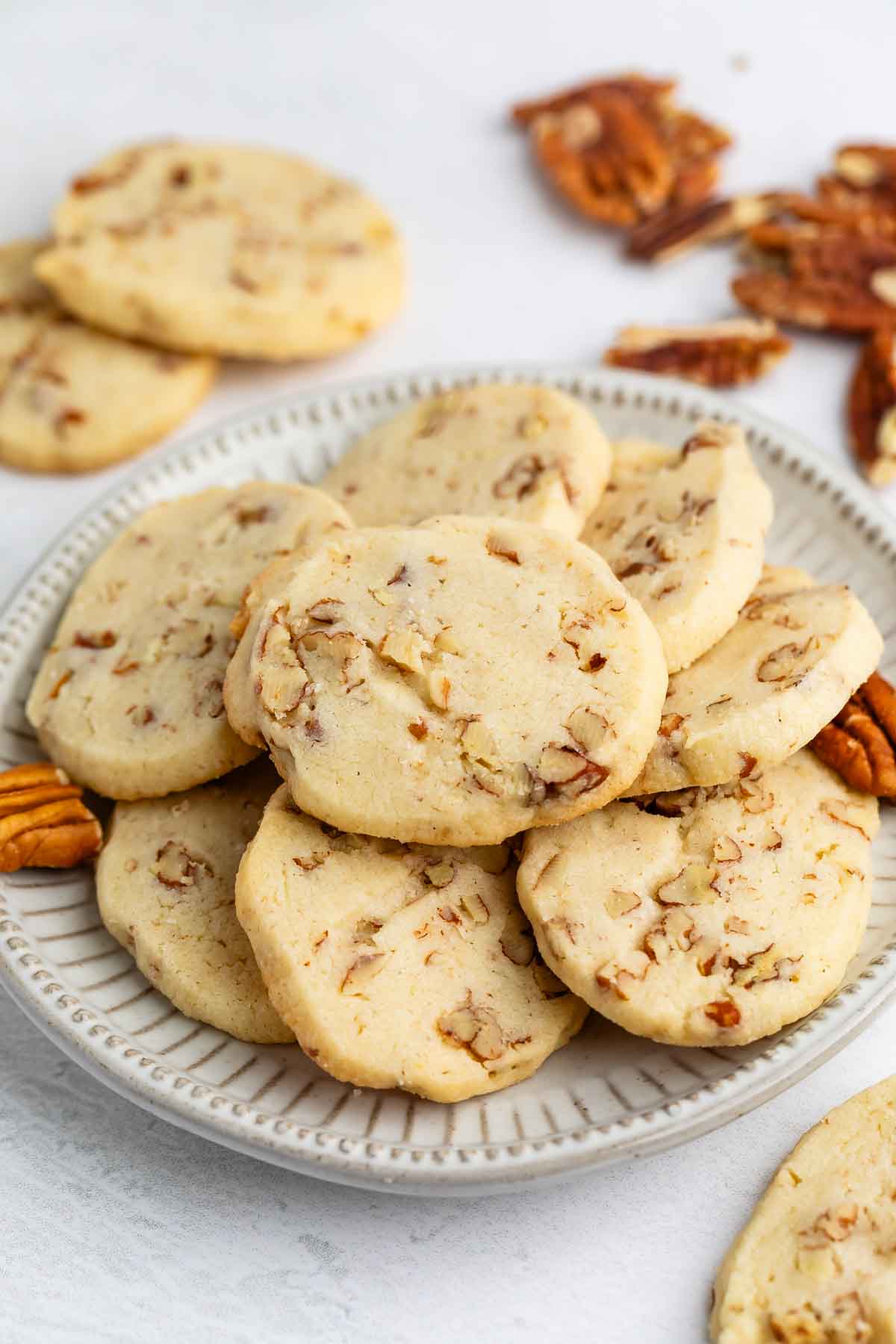 sliced cookies with pecans baked in and laid out on a grey plate.
