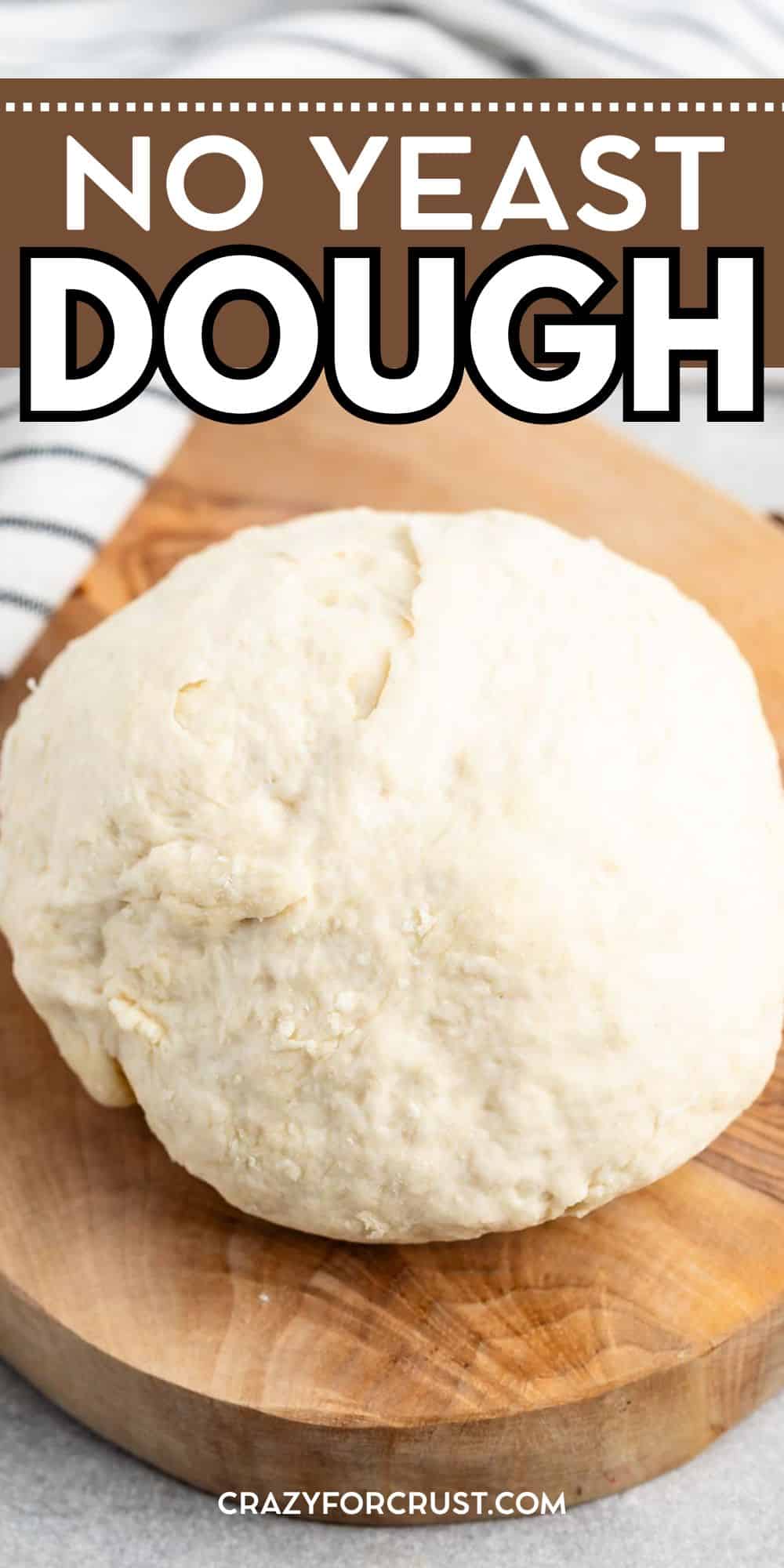 A ball of no yeast dough sits on a wooden cutting board, with a striped kitchen towel in the background. Text above reads, No Yeast Dough.