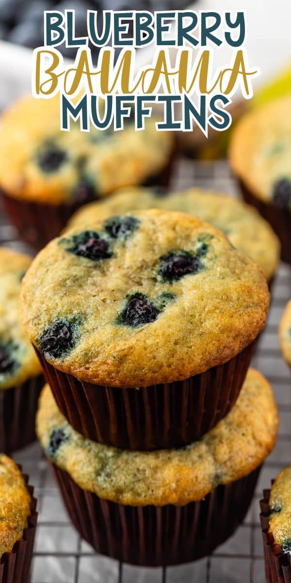 Two blueberry banana muffins are stacked on top of each other, with more muffins in the background, all resting on a cooling rack. Text above reads “Blueberry Banana Muffins.”.