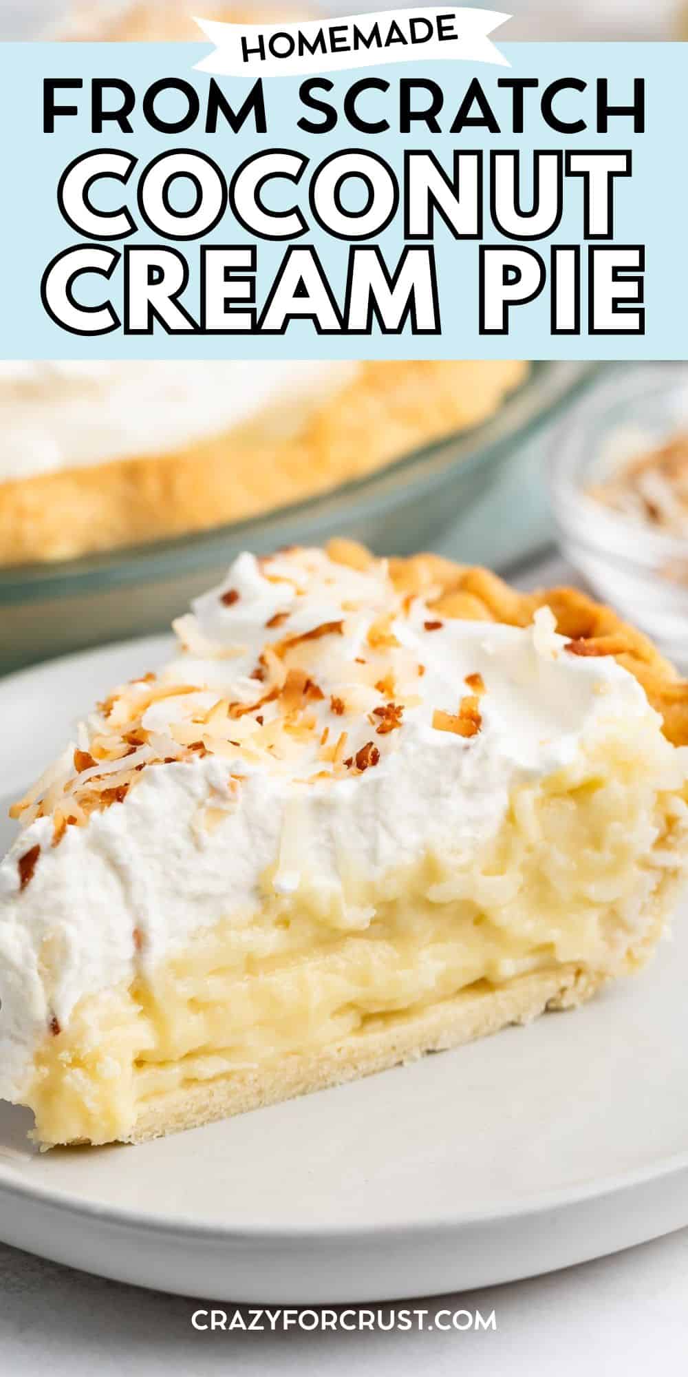 A slice of coconut cream pie with a flaky crust, creamy filling, whipped topping, and toasted coconut flakes on top sits on a plate, with the rest of the pie in the background. Text reads Homemade From Scratch Coconut Cream Pie.