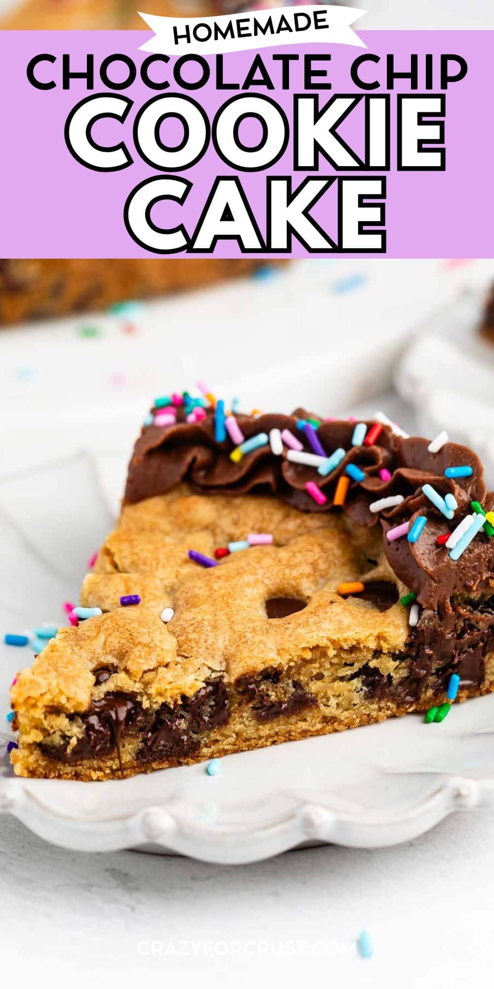 A slice of chocolate chip cookie cake topped with chocolate frosting and colorful sprinkles on a white plate. The text above reads Homemade Chocolate Chip Cookie Cake.