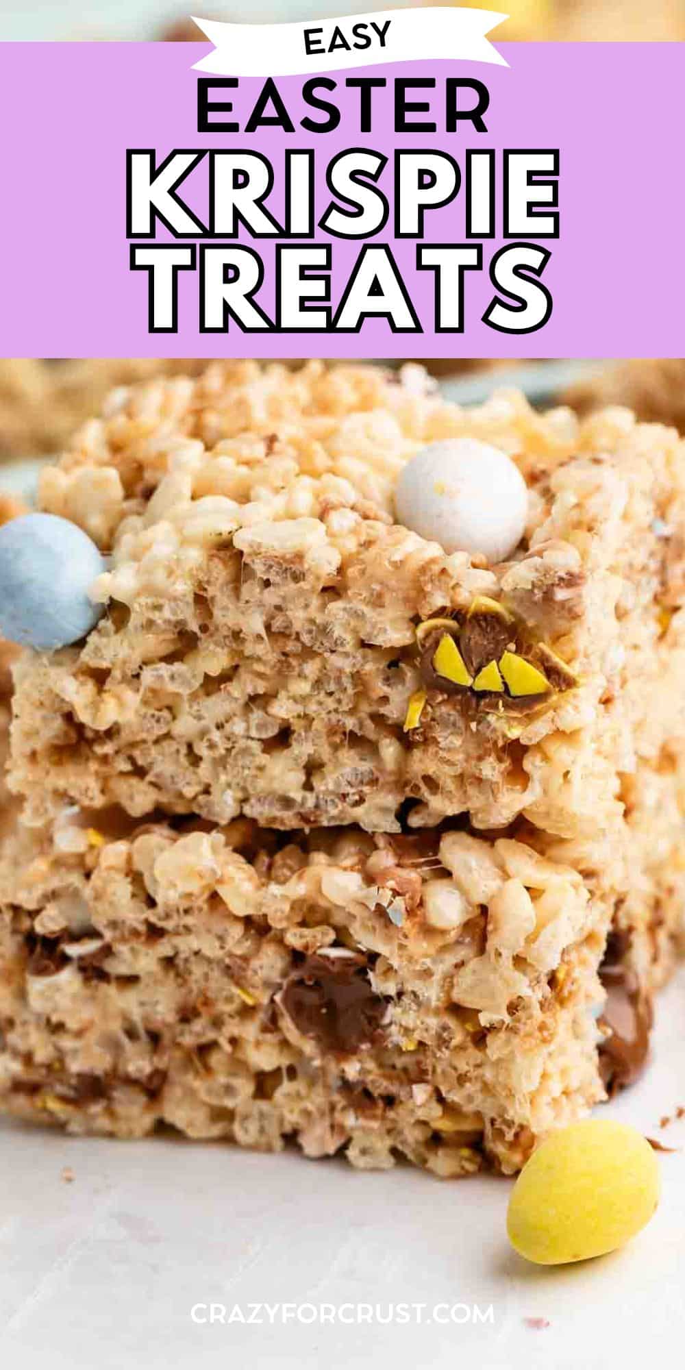 Two Rice Krispie treat squares are stacked on each other, with pastel-colored candy eggs and chocolate pieces mixed in. The top of the image has text reading Easy Easter Krispie Treats.