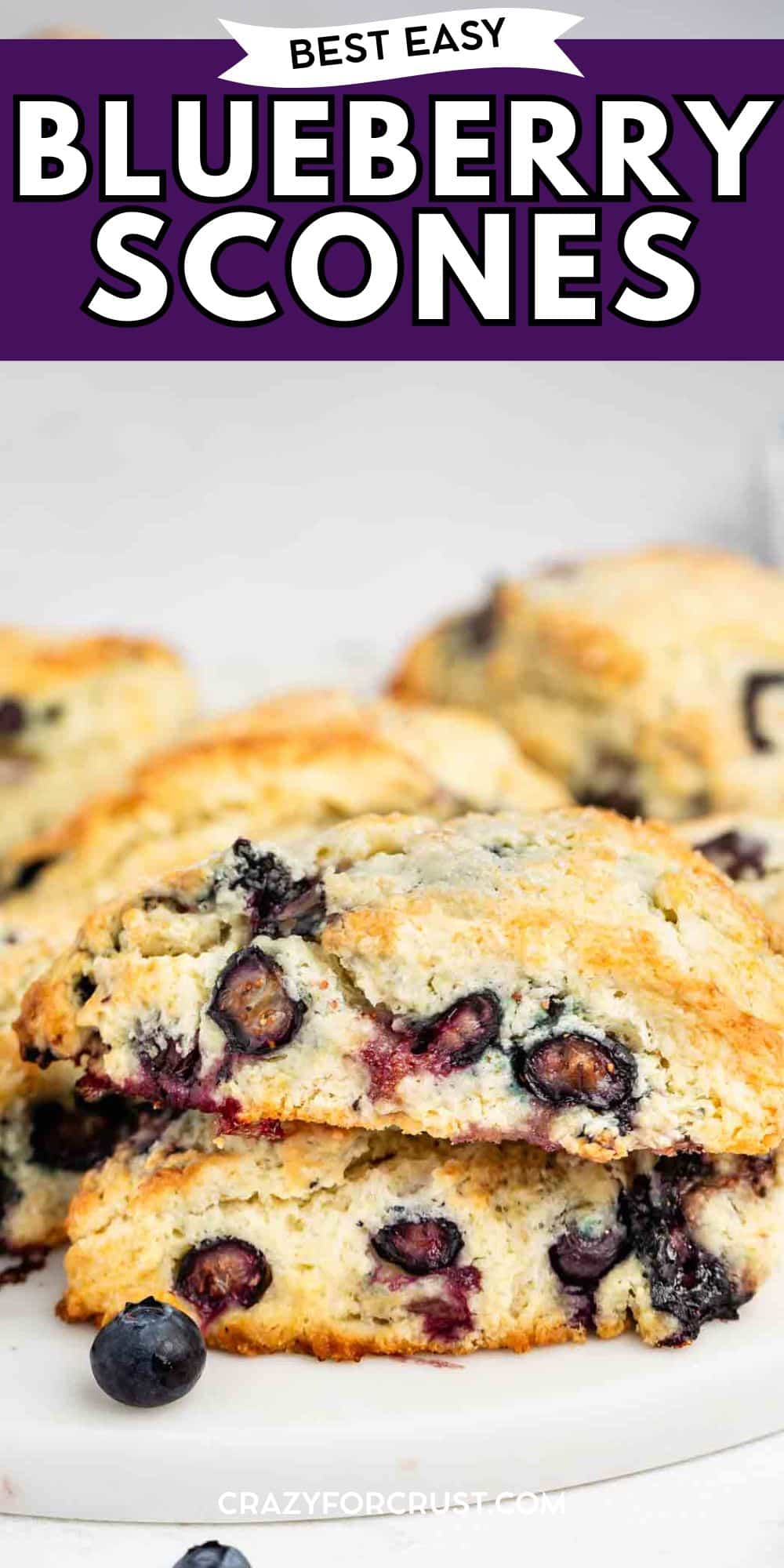 A close-up of flaky, golden-brown blueberry scones with fresh blueberries inside, stacked on a white surface. The text above reads Best Easy Blueberry Scones.