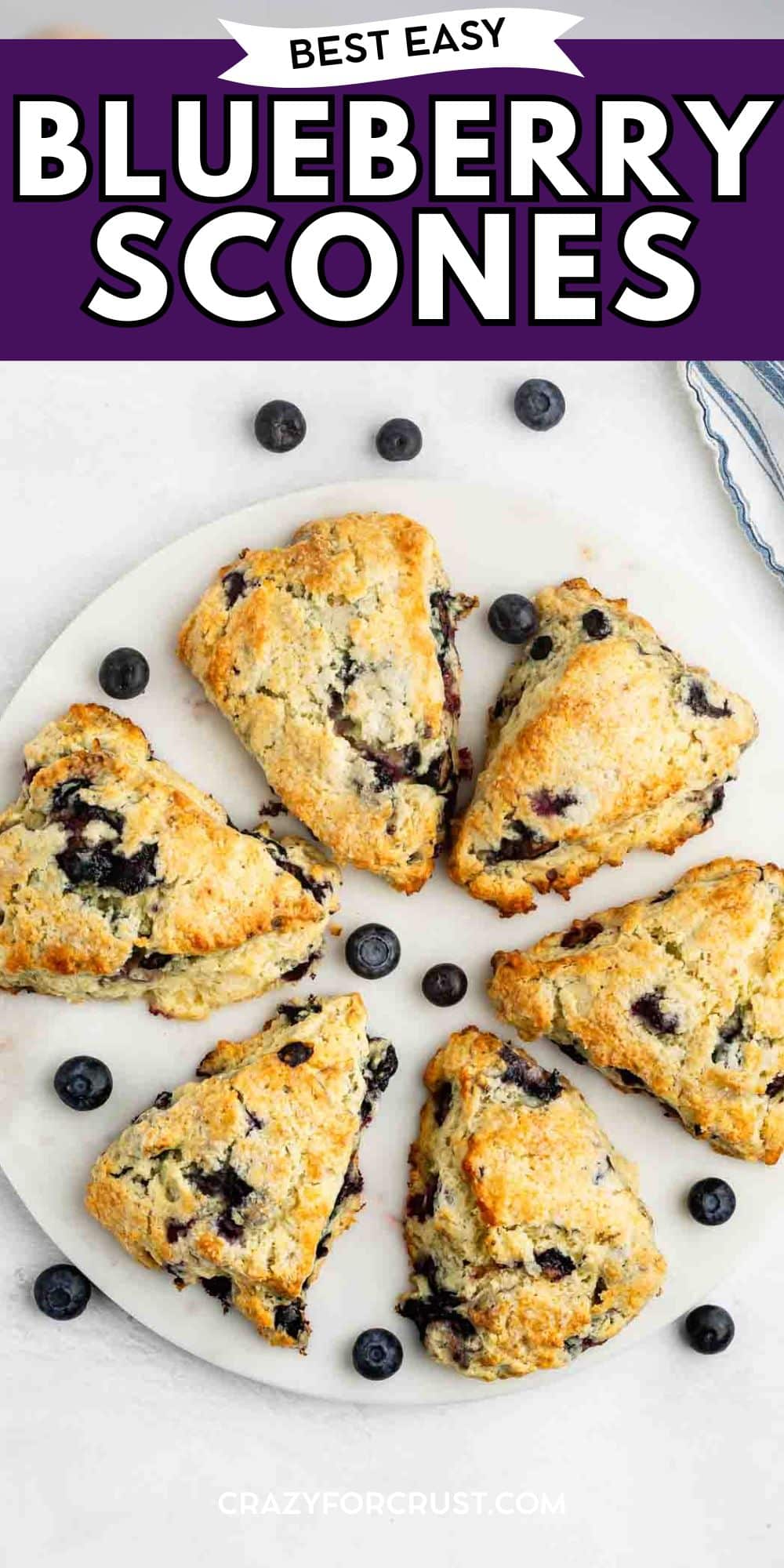 A round white plate holds six golden-brown blueberry scones, surrounded by scattered fresh blueberries. The top of the image reads Best Easy Blueberry Scones in bold text on a purple background.