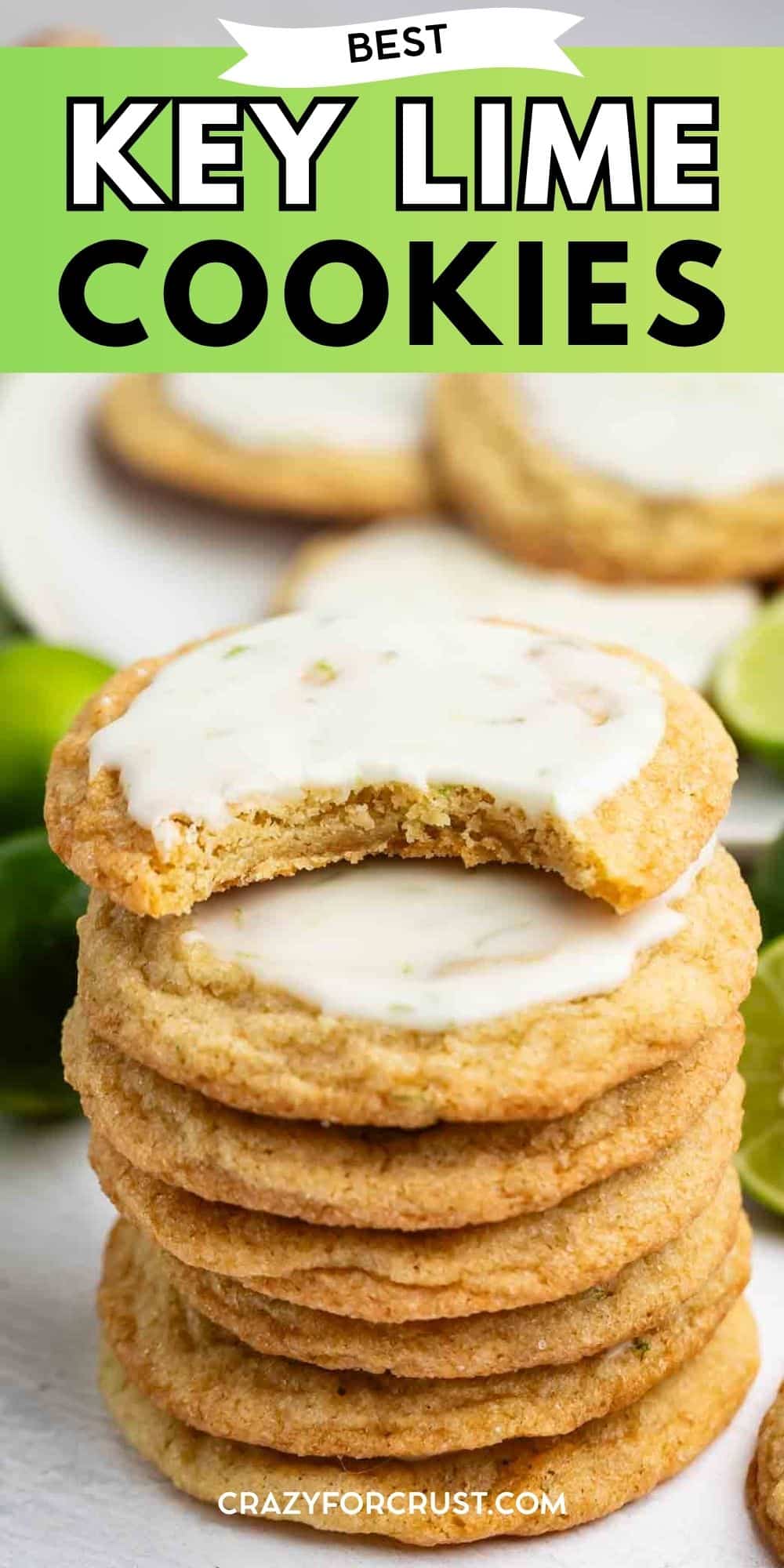 A stack of key lime cookies with white icing is shown, with the top cookie missing a bite. More cookies and lime slices are blurred in the background. Text at the top reads, Best Key Lime Cookies.