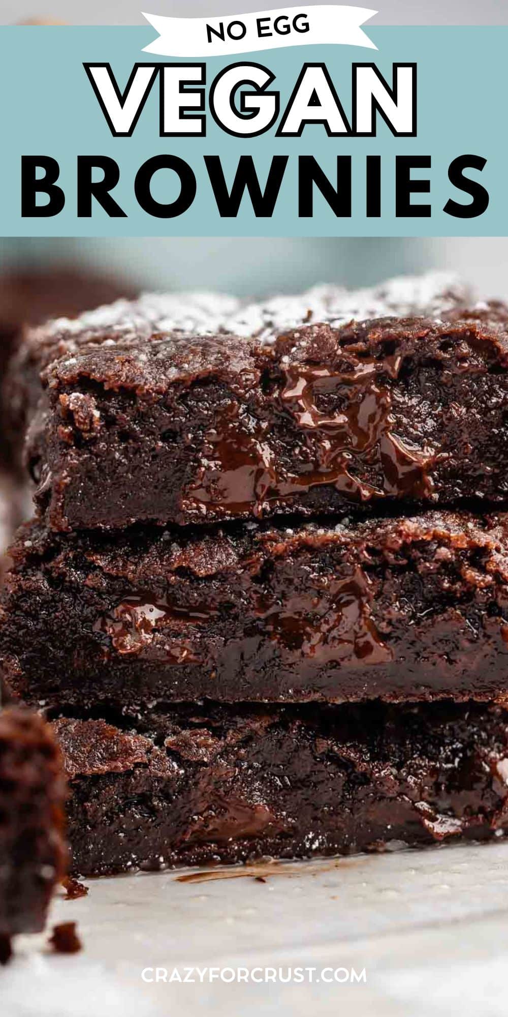 Close-up of a stack of rich, fudgy vegan brownies with melted chocolate inside. Text at the top reads No Egg Vegan Brownies, and at the bottom, crazyforcrust.com.