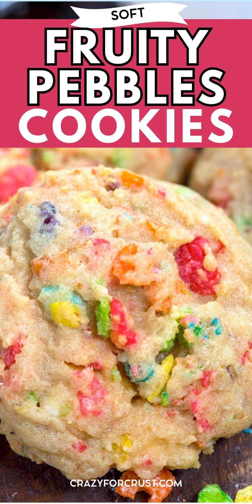 A close-up of a soft cookie filled with colorful Fruity Pebbles cereal pieces, with the text Soft Fruity Pebbles Cookies at the top and crazyforcrust.com at the bottom.