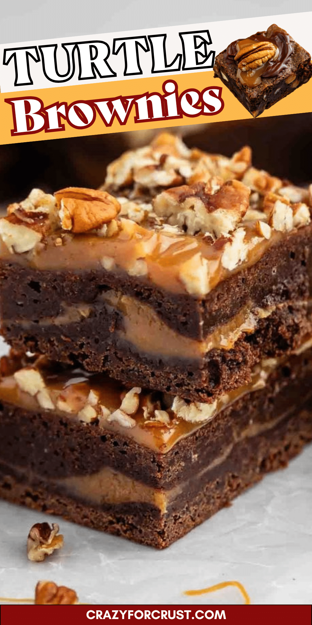 Two stacked brownies topped with chopped pecans and caramel, showing a gooey caramel layer inside. Text reads Turtle Brownies with a small brownie image and crazyforcrust.com at the bottom.