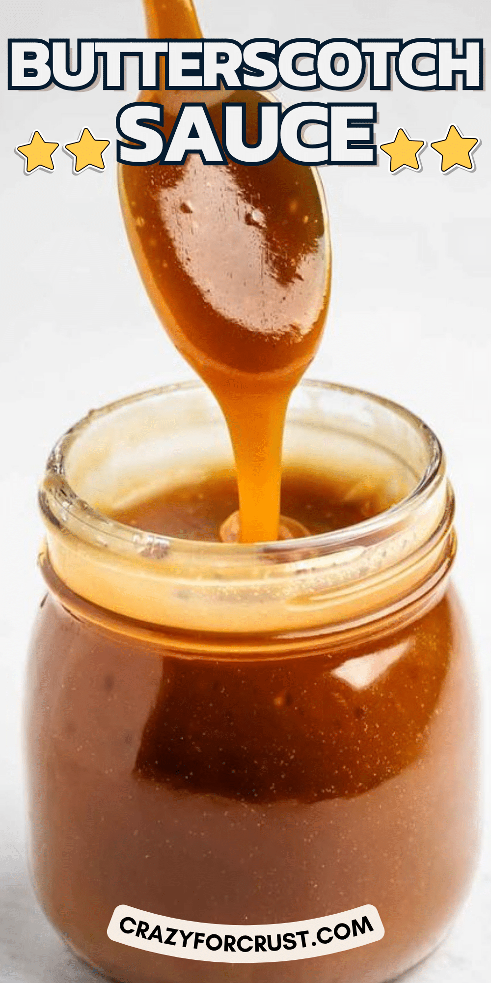 A spoon drizzling thick butterscotch sauce into a glass jar, with BUTTERSCOTCH SAUCE in bold text above and crazyforcrust.com below.