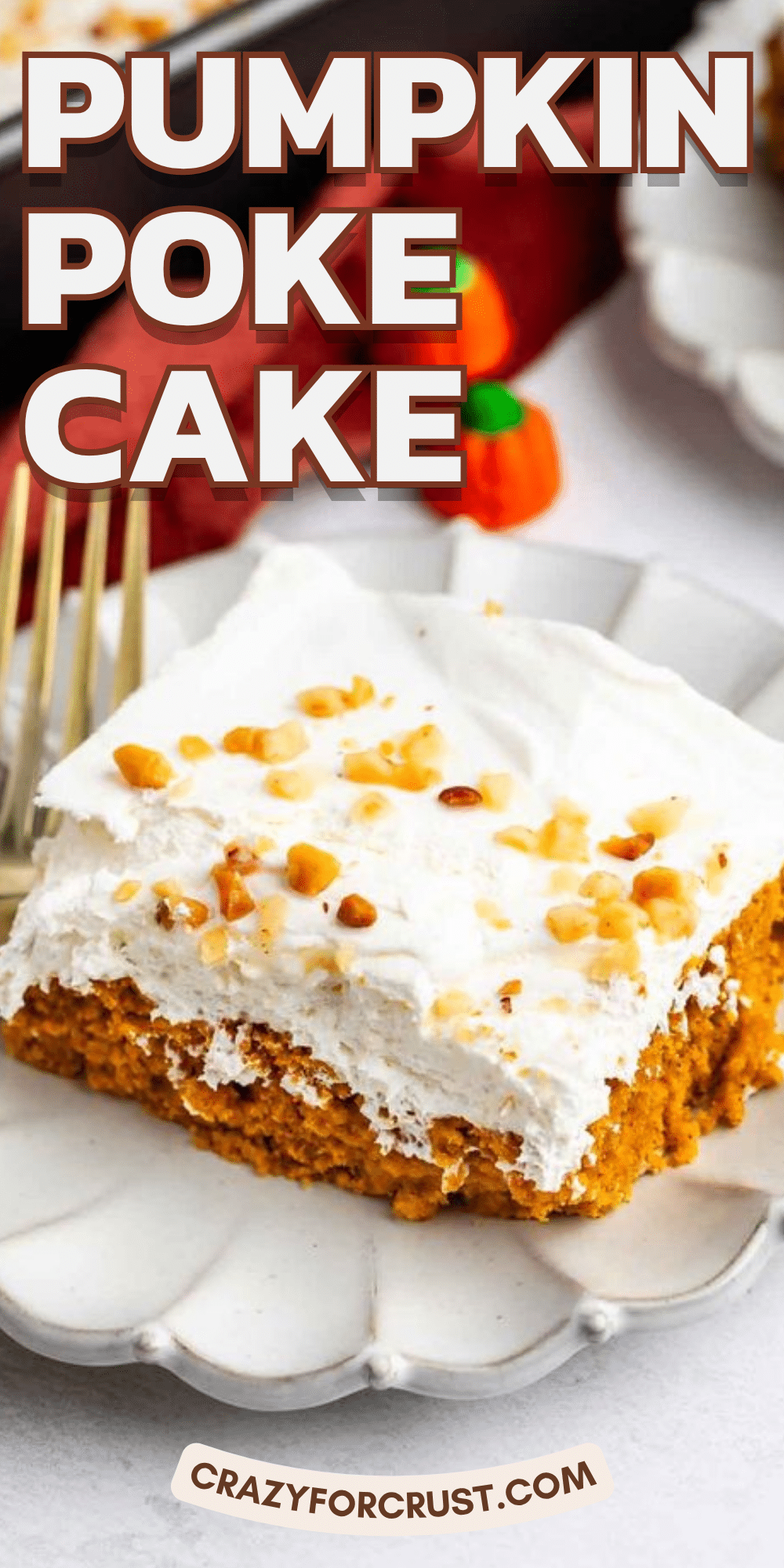 A slice of pumpkin poke cake topped with whipped cream and chopped nuts sits on a white plate with a gold fork. The background features festive autumn decor and the text Pumpkin Poke Cake..