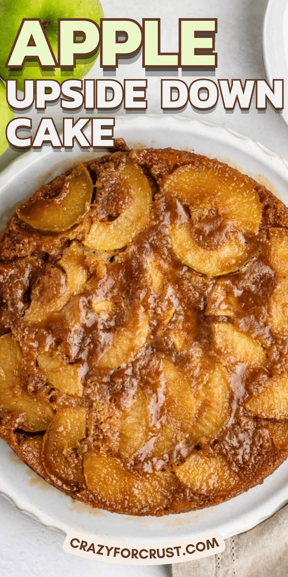 A round apple upside down cake with caramelized apple slices on top, displayed in a white dish. Text reads Apple Upside Down Cake and crazyforcrust.com. This delicious apple upside down cake is perfect for any occasion, featuring tender apples and a rich caramel flavor in every bite.