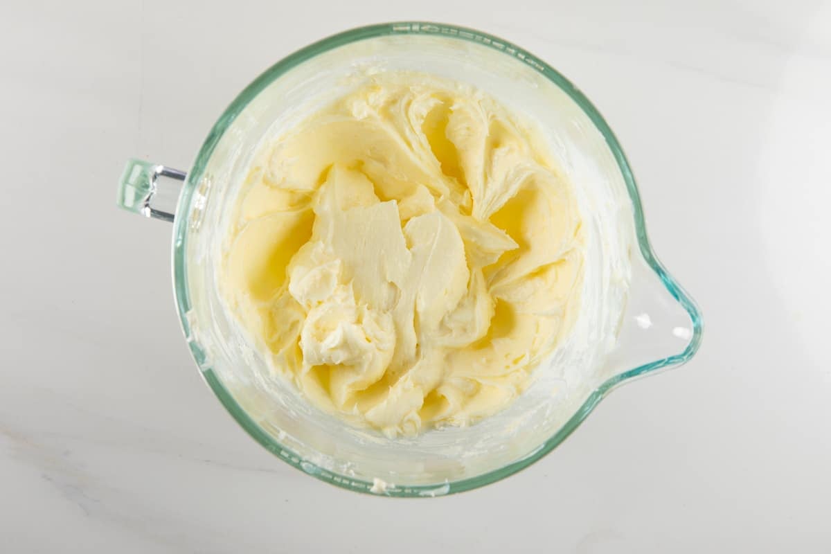 Creamy pale yellow frosting in a glass mixing bowl.